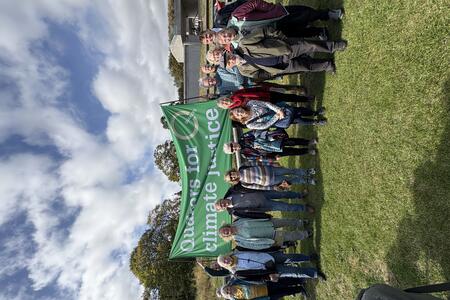 Several Quakers stand under a Quakers for Climate Justice banner outside the Scottish Parliament