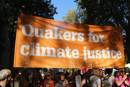 Pictures of Quakers holding an orange 'Quakers for climate justice' banner as part of the 2019 climate strike