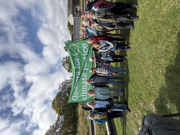 Several Quakers stand under a Quakers for Climate Justice banner outside the Scottish Parliament
