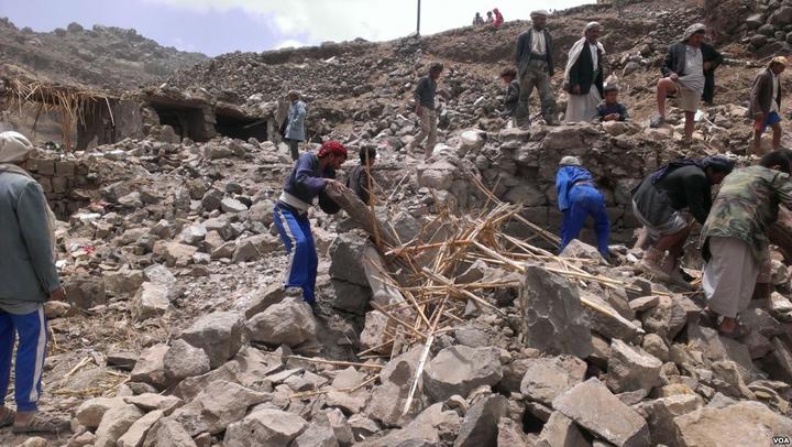 Villagers scour rubble for belongings scattered during the bombing of Hajar Aukaish - Yemen - in April 2015