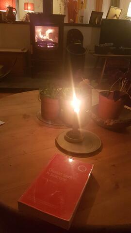 Picture of Quaker Faith and Practice, a candle and a lit fireplace